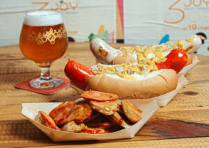 Fábrica de cervejas de Curitiba promove a OktoberJoy, com gastronomia alemã, chope de metro e música ao vivo